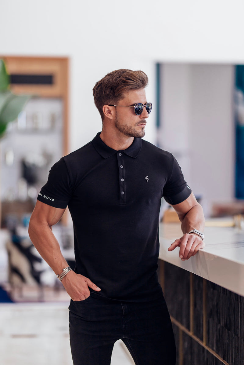 Klassisches schwarzes Poloshirt von Father Sons mit elastischem FS-Logo auf den Ärmeln und schwarzem Metallemblem – FSH631