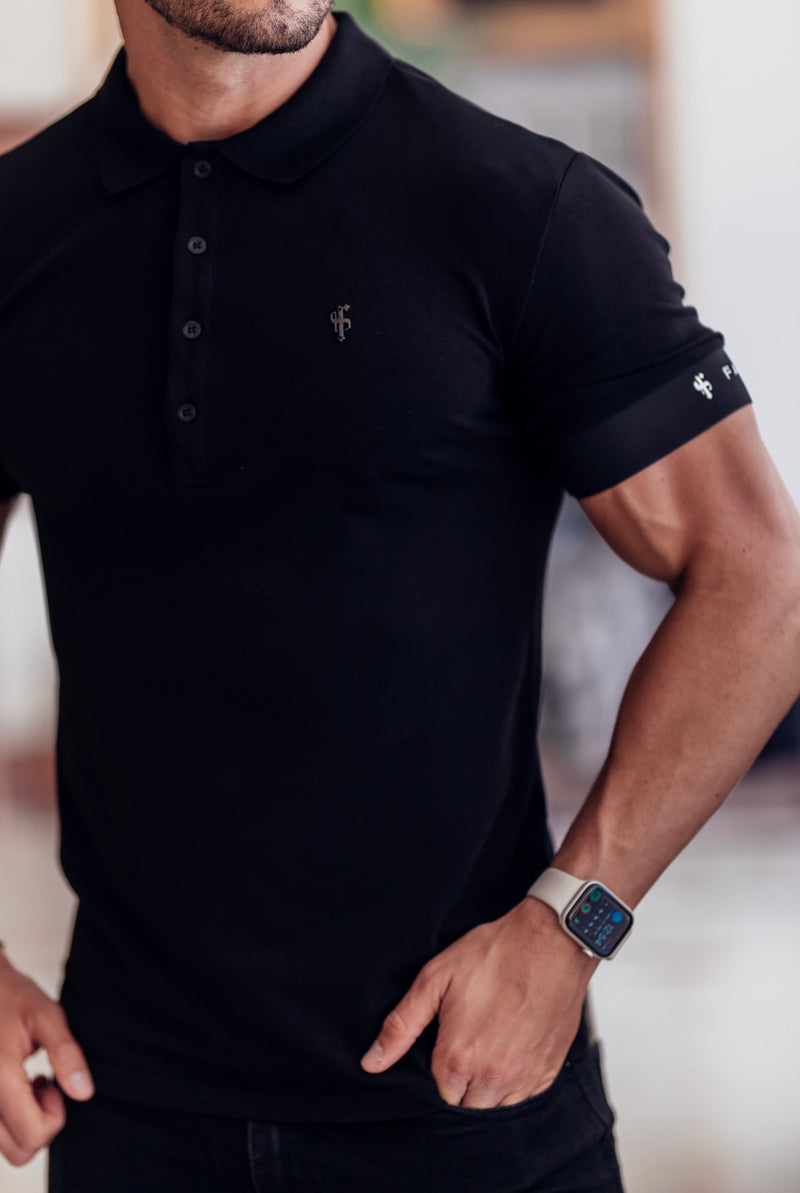 Klassisches schwarzes Poloshirt von Father Sons mit elastischem FS-Logo auf den Ärmeln und schwarzem Metallemblem – FSH631